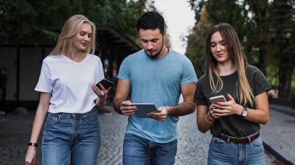 Image of three teens looking at their mobile phones